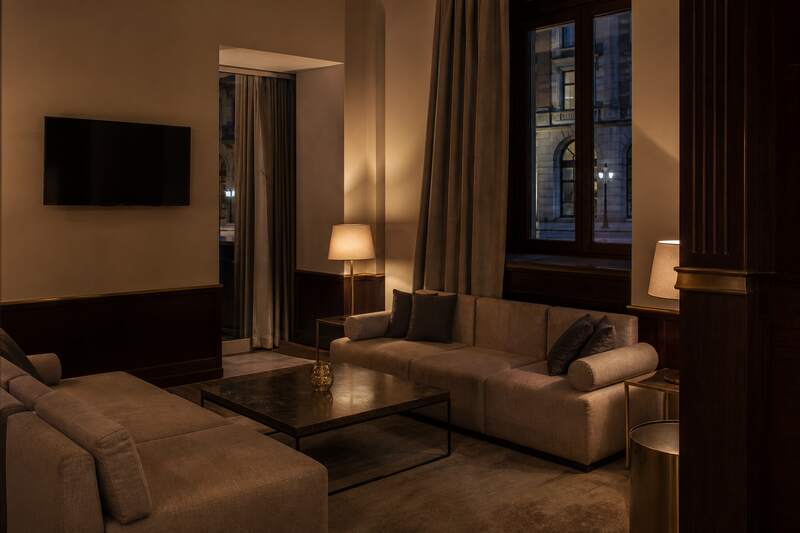 Hotelowy salon wieczorny z fotelami i ciepłym światłem lamp